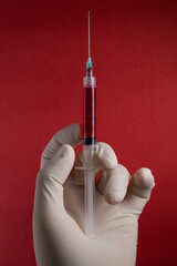 Blood donation topic, doctor hand holding a syringe with blood