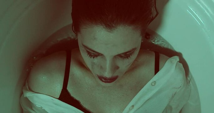 compulsion, obsession - woman diving dressed in the tub to wash away the guilt