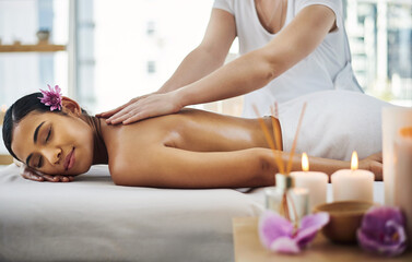 Put yourself first and book that massage. Shot of an attractive young woman getting a massage at a spa.