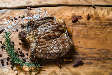 Fried steak on the bone on a wooden surface