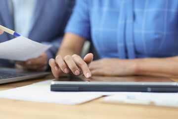 Business people talking using digital tablet sitting at office table