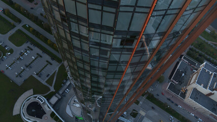 Aerial top view of a skyscraper with glass facade building. Stock footage. Glass tower, beautiful city building.