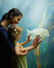 See, he's a friendly fish. Shot of a mother and daughter on an outing to the aquarium.