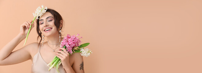 Happy young woman with bouquet of beautiful flowers on beige background with space for text. Hello spring