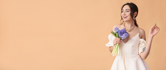 Beautiful happy young woman with bouquet of flowers on beige background with space for text. Hello spring