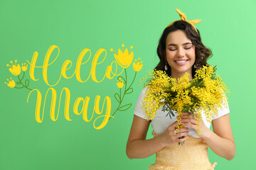 Beautiful young woman with bouquet of mimosa flowers and text HELLO, MAY on green background