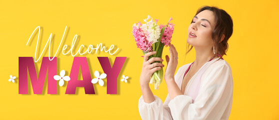 Beautiful young woman with bouquet of flowers and text WELCOME, MAY on yellow background