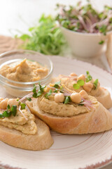 Plate with pieces of bread and tasty hummus on table, closeup