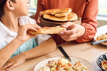 Muslim little boy with his mother having breakfast together. Celebration of Eid al-Fitr