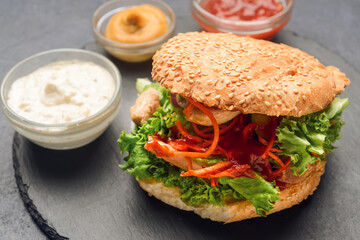 Fresh doner kebab in bun with sauces on dark background
