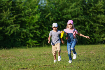 Fototapeta premium Cute little children playing frisbee outdoors
