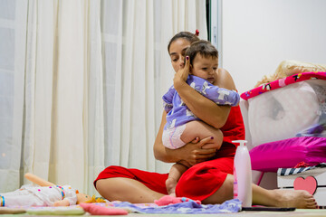Obraz premium young latin mother holding her baby to put her to sleep