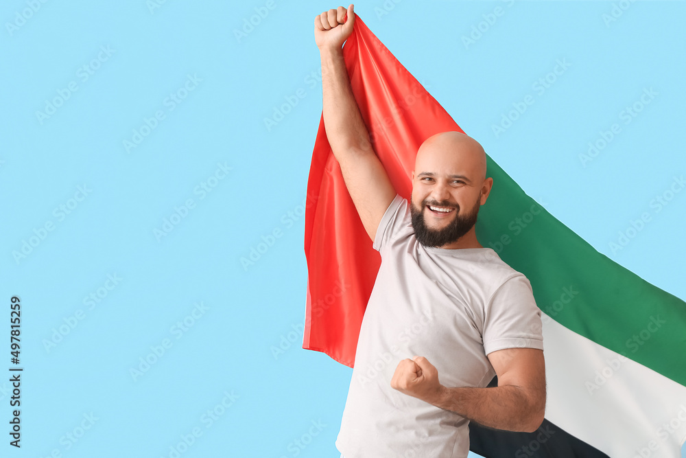 Wall mural Man with the national flag of UAE on color background