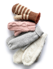 Different warm mittens on white background