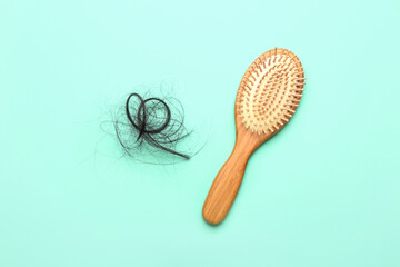 Clump of hair and brush on blue background