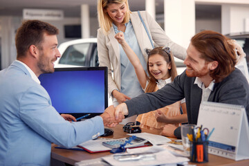 Obraz premium family buying a new car in city dealership and talking with salesman