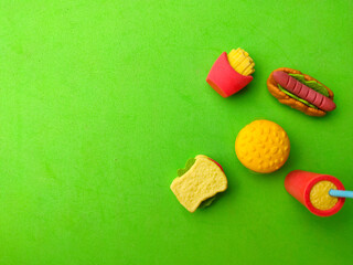 Top view fast food toys on a green background with copy space.