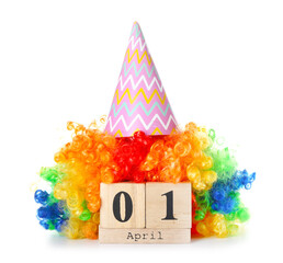 Calendar with date of April Fool's Day, colorful wig and party hat on white background