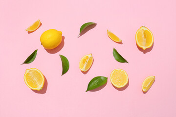 Many ripe lemons and slices on pink background, top view