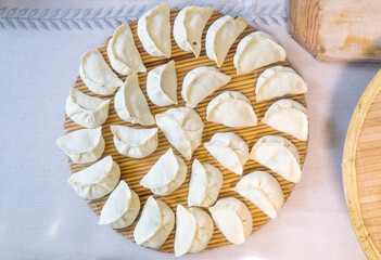 Raw Chinese dumplings on the reed plate ready for steaming