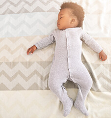 Growing babies need plenty of sleep. High angle shot of a little baby boy sleeping on a bed.