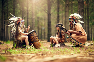 Playing the song of their people. Shot of a young woman and her two daughters playing dressup in...