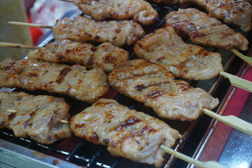 Close-up Thai grilled skewered milk pork, Roasted Pork or barbecue pork - local Thai street food style.