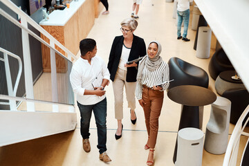 Keeping success firmly in their stride. High angle shot of a group of businesspeople walking...
