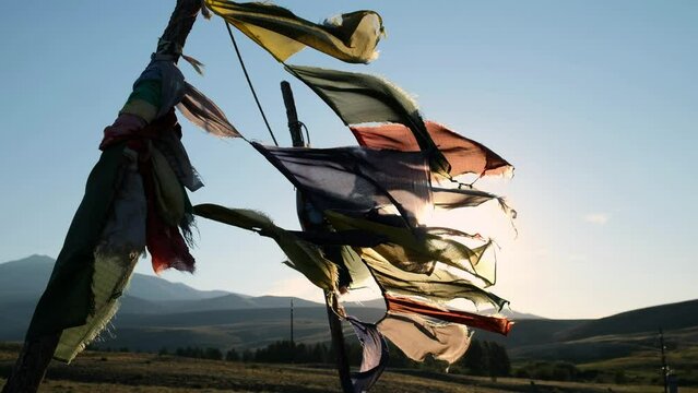 Religious tibetan buddhist prayer flags are floating in the wind on blue sky background.
