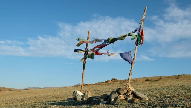Religious tibetan buddhist prayer flags are floating in the wind on blue sky background.