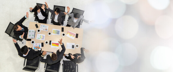 Successful business people celebrate together with joy at office table shot from top view . Young...