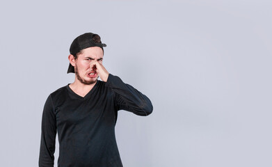 A man with covering his nose, a guy with a face of unpleasant odors, concept of bad smells