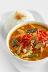 traditional thai chicken red curry with rice on white background