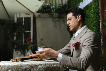 Man in suit choosing a fabric in swatch.