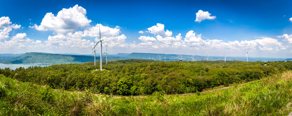 Landscape of many wind turbine on the vast grassland with mountains and sky as a background in...
