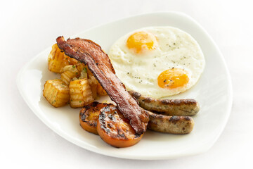 australian breakfast with fried eggs, sausage, bacon and potato