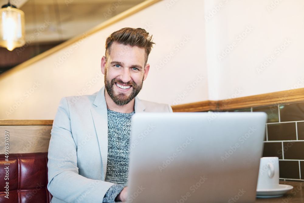 Poster working on my own schedule. cropped portrait of a modern businessman using his laptop in a coffee sh
