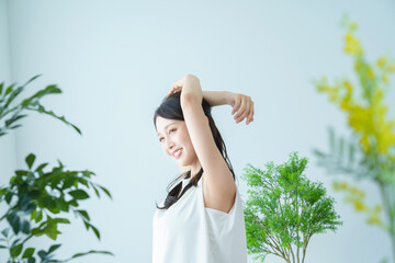 窓際で光を浴びながら深呼吸をする女性