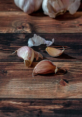 Fresh garlic bulbs and a garlic press on an old wooden board and a burlap backing.