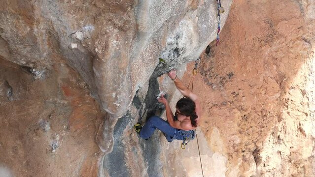 strong man climbs a difficult climbing route. rock climbing as an olympic sport. outdoor workout.