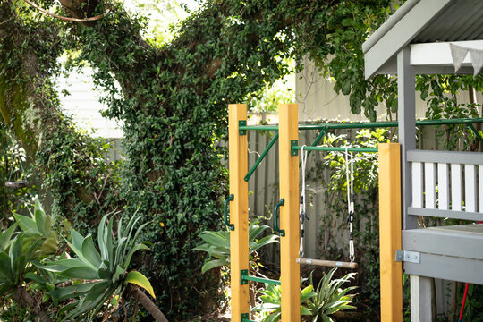Close up image of monkey bars, jungle gym, attached to backyard cubby house
