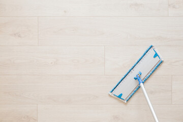 Microfiber mop pad with stick on light laminate background. Floor washing at home, office or other...