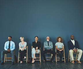 Consider everything a test, even the possible extended 10-minute wait. Shot of a group of well-dressed business people seated in line while waiting to be interview.