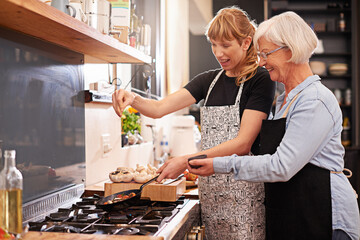 Learning from master chef. Shot of a senior woman and a younger woman cooking together.