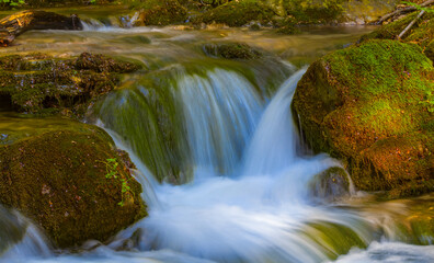Fototapeta na wymiar closeup small waterfall on mountain river, natural mountain canyon scene