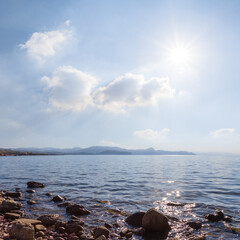 quiet sea coast with stones at sunny summer day