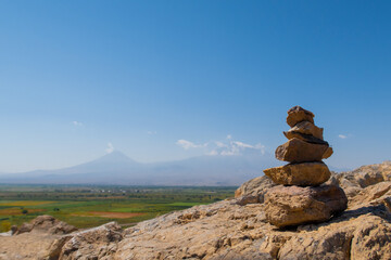 Ararat mountain vineyards with rocks cairn scenic view on the hill by Khor Virap monastery. Grape field in Ararat valley. Armenia picturesque mountain range landscape. Stock photography