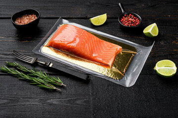 Raw salmon vacuum sealed bag for sell, with herbs, on black wooden table background, with copy space for text