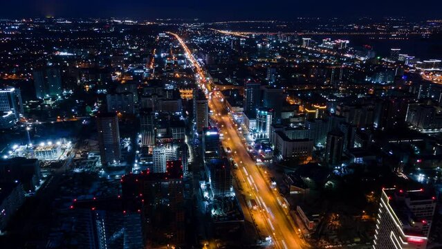 Aerial photography from a great height. A big night city with car traffic. Bright night orange lights and footprints from headlights. Night Aerial 4k.