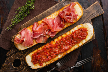 Spanish tomato and jamon toast set, on old dark  wooden table background, top view flat lay